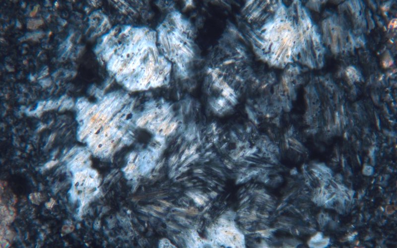 Grana di materiale di cottura con cristalli di anidrite fibrosa (frammento di stucco da San Pietro di Quarazze, XPL, larghezza immagine 400 µm)